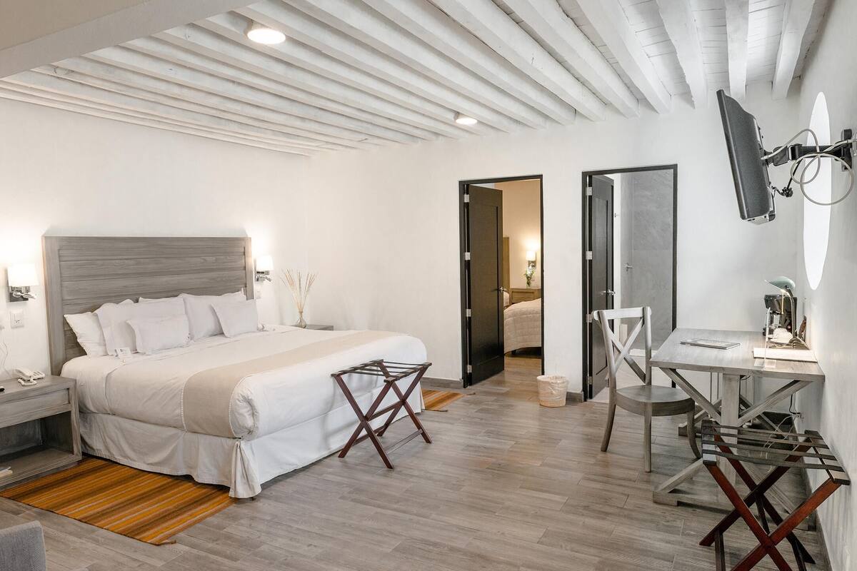 Et moderne hotelværelse med en stor seng, et skrivebord og en stol.