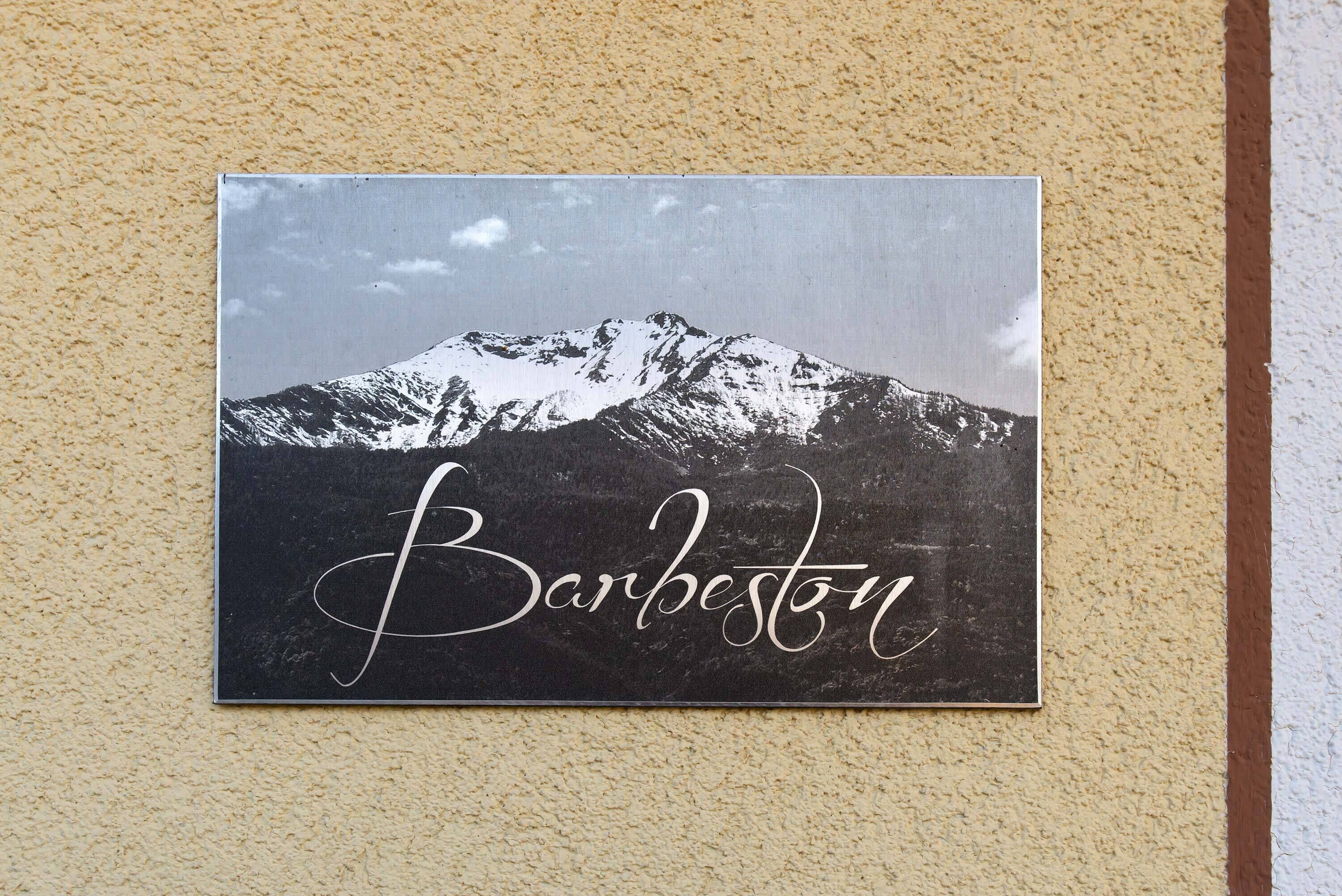 A sign with a mountain and the word "Barbestaun" on a textured wall.