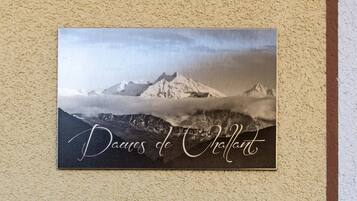 Una fotografia incorniciata di un paesaggio montano con la scritta "Daues de Châtillon" su un muro strutturato.