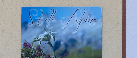 A wall-mounted sign with the text "Stella Apina" and a floral background.