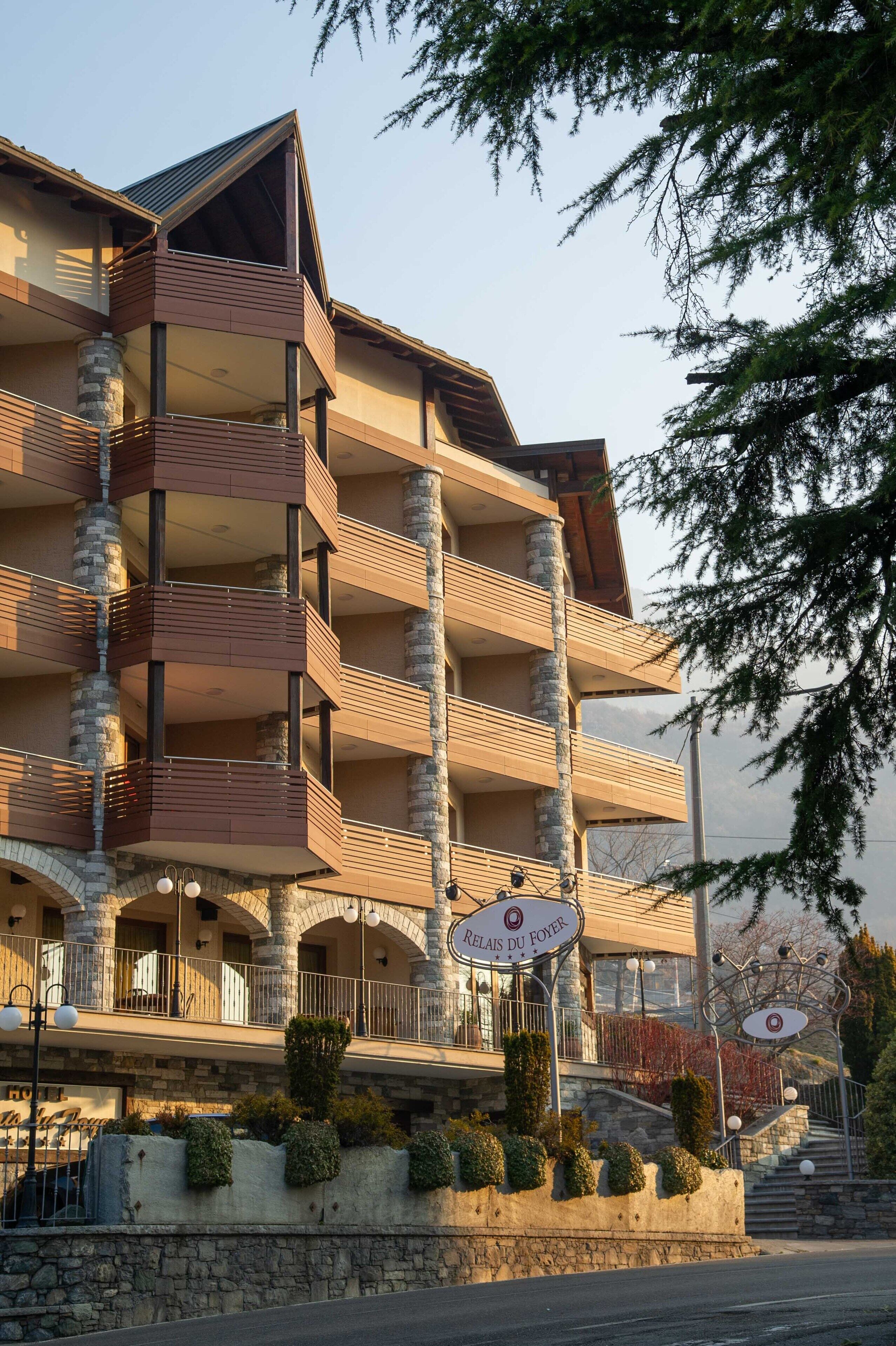 Ett hotell med flera våningar, balkonger, stenkärnor och en skylt med texten ”RELAIS DU POWER”.