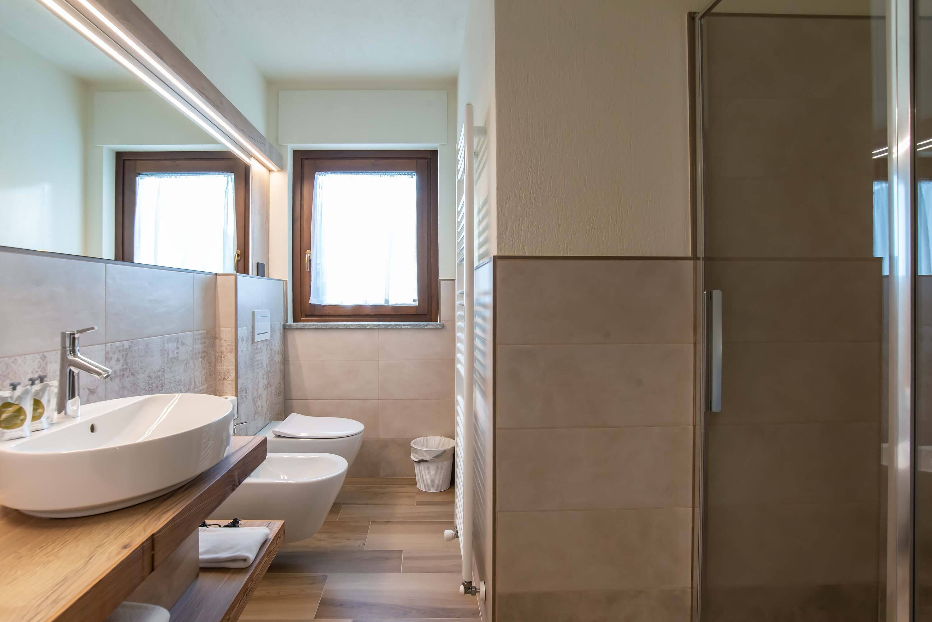 Un baño moderno con un lavamanos grande, un inodoro y una zona de ducha.