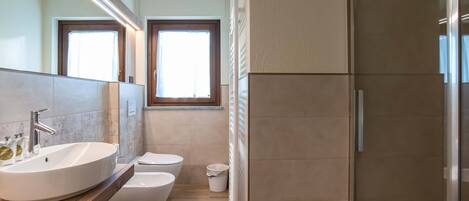 Un baño moderno con un lavamanos grande, un inodoro y una zona de ducha.