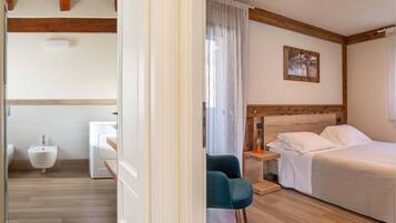 Una camera da letto con un letto, un comodino e una finestra con tende.