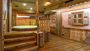A wooden interior with a hot tub, wooden stairs, and a rustic design.