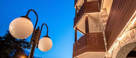 Un hotel con terraza al aire libre, arquitectura de piedra y vistas a montañas.