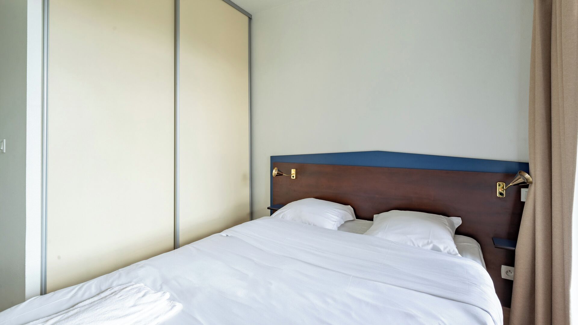 Ein Hotelzimmer mit einem Bett, einem Kleiderschrank und einem Nachttisch.