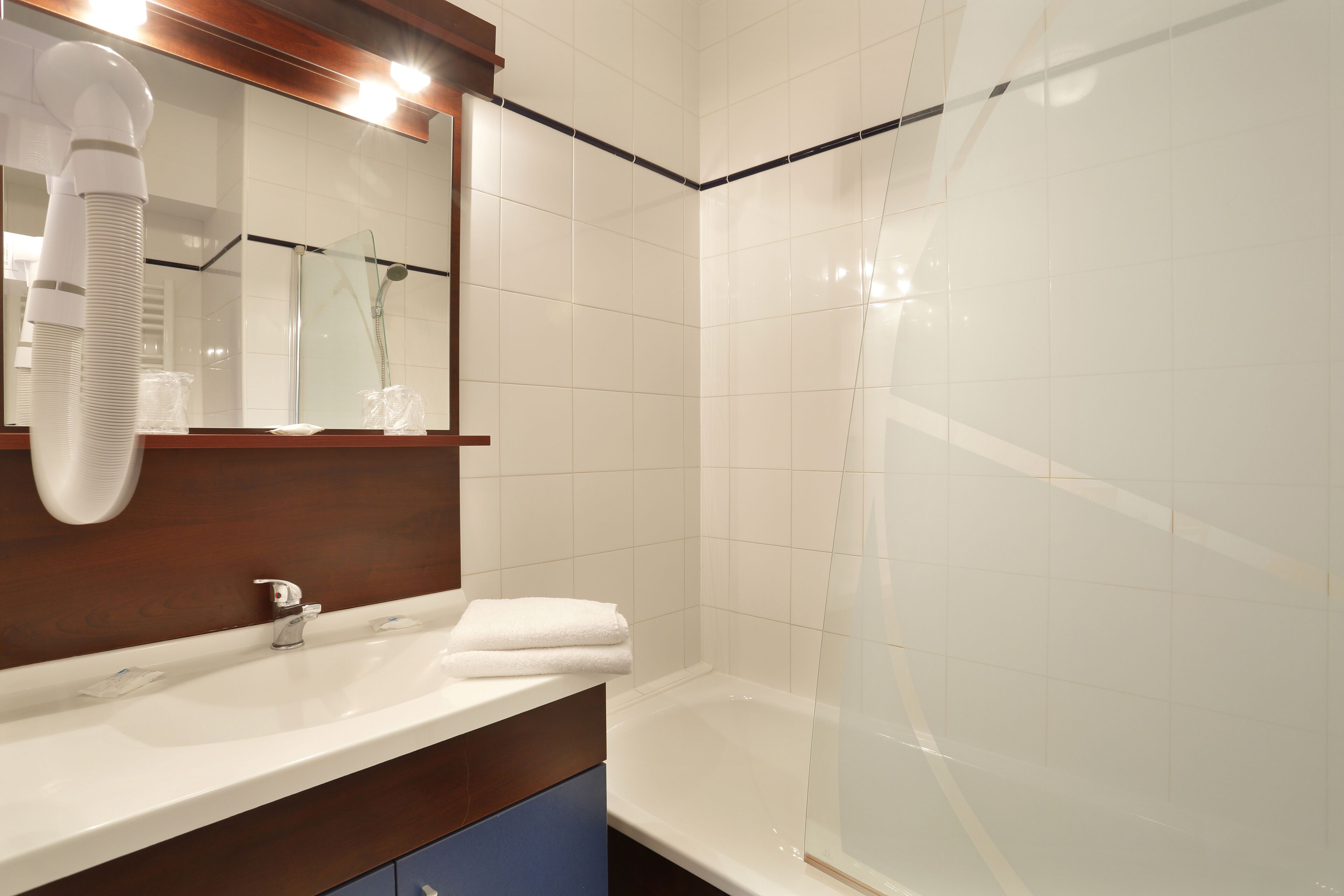 Ein Badezimmer mit Waschbecken, Spiegel und Duschkabine.