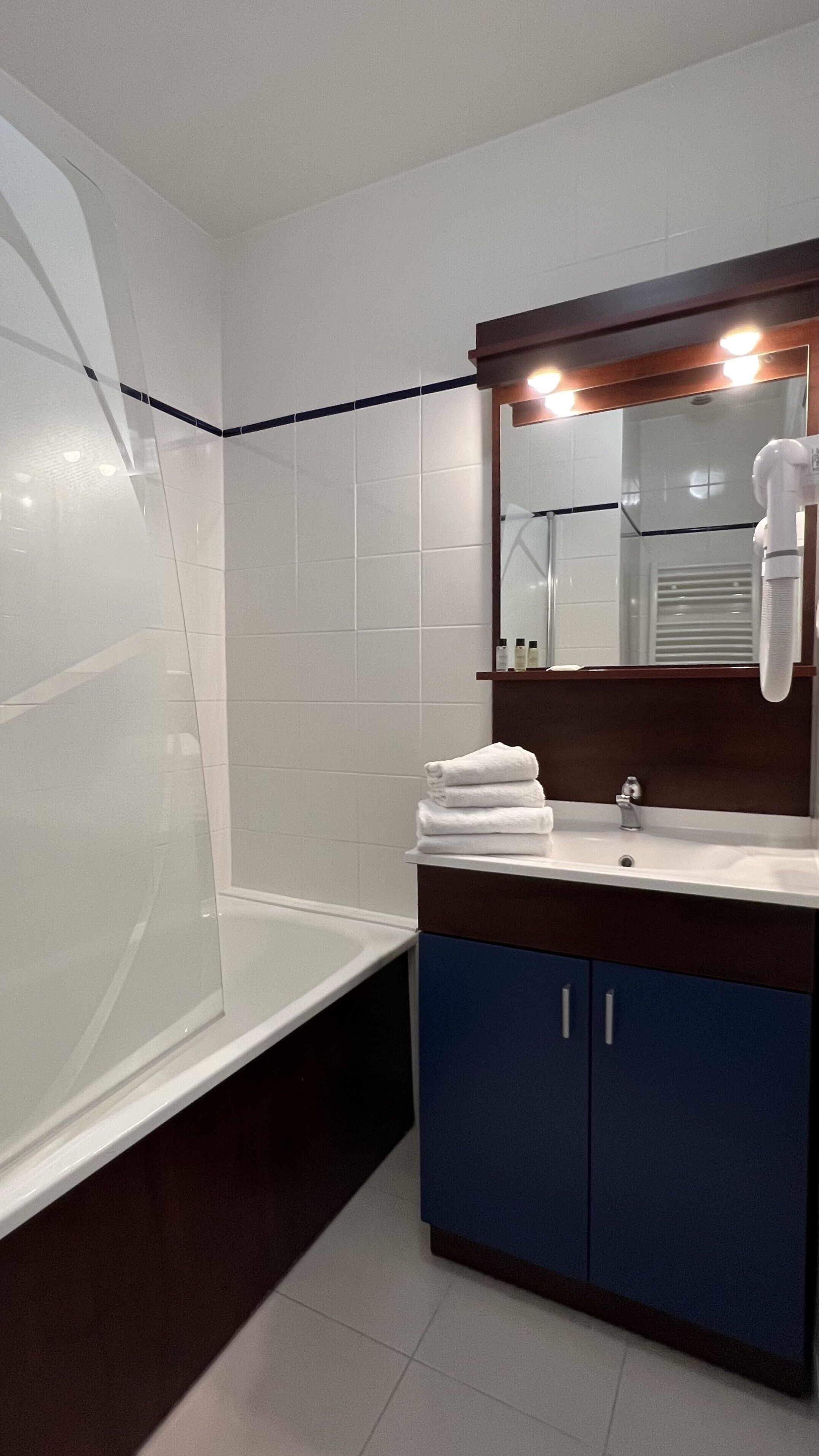 A modern bathroom with a bathtub, a sink, and a mirror.