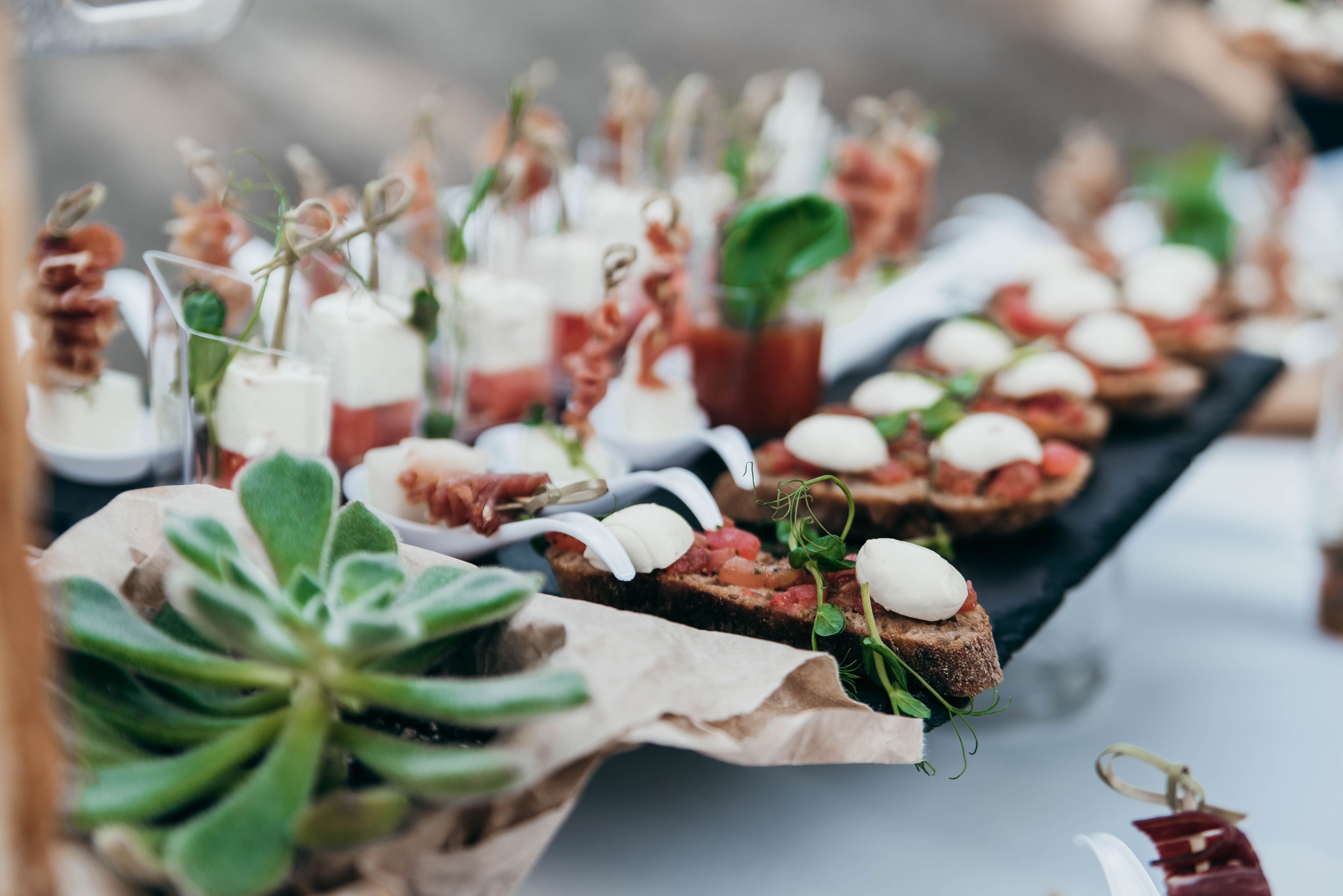 A variety of appetizers arranged on a table, including items with cheese, meat, and garnishes.