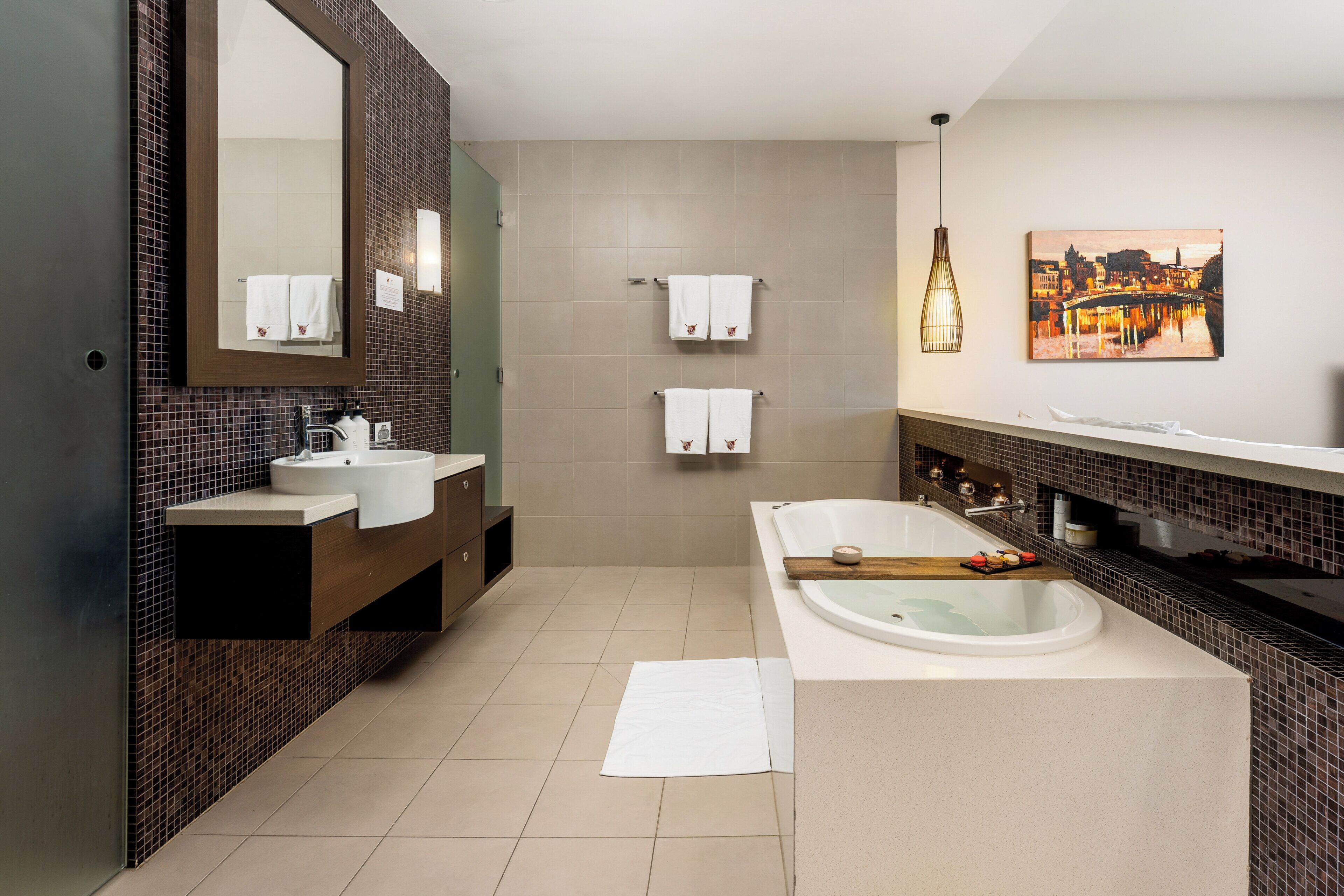 A modern bathroom with a large bathtub, a double sink vanity, and a mirror.
