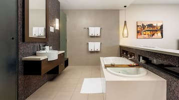 A modern bathroom with a large bathtub, a double sink vanity, and a mirror.