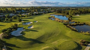 A golf course with bunkers, water hazards, and a clubhouse. - Chateau Elan At The Vintage (Pokolbin)