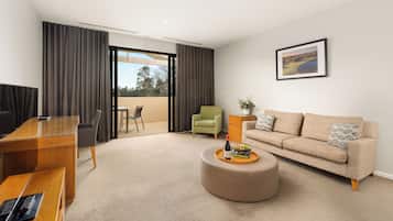 A modern living room with a sofa, a dining table, and a TV.