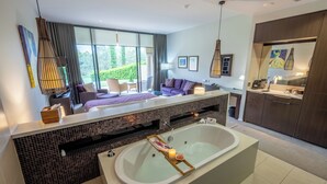 A modern bathroom with a large bathtub, a vanity with a mirror, and a seating area with a sofa and chairs. - Chateau Elan At The Vintage (Pokolbin)