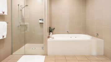 A modern bathroom with a glass-enclosed shower, a freestanding bathtub, and a glass door shower.