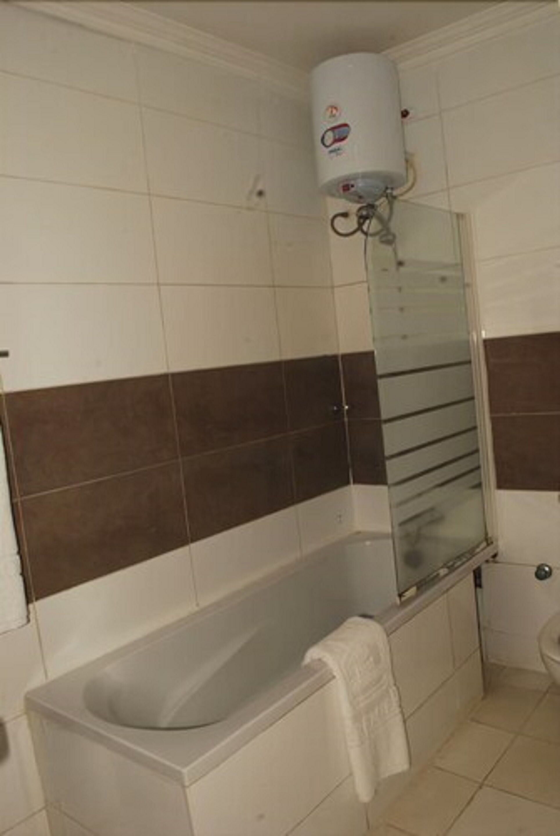 A bathroom with a bathtub, a glass shower enclosure, and a white toilet.