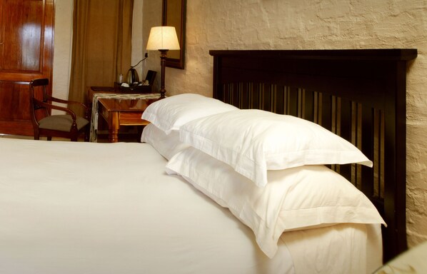 A neatly made bed with white linens in a hotel room. - Critchley Hackle (Dullstroom)