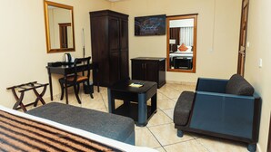 Una sala de estar con un sofá, una mesita, un aparador y un escritorio con una silla.