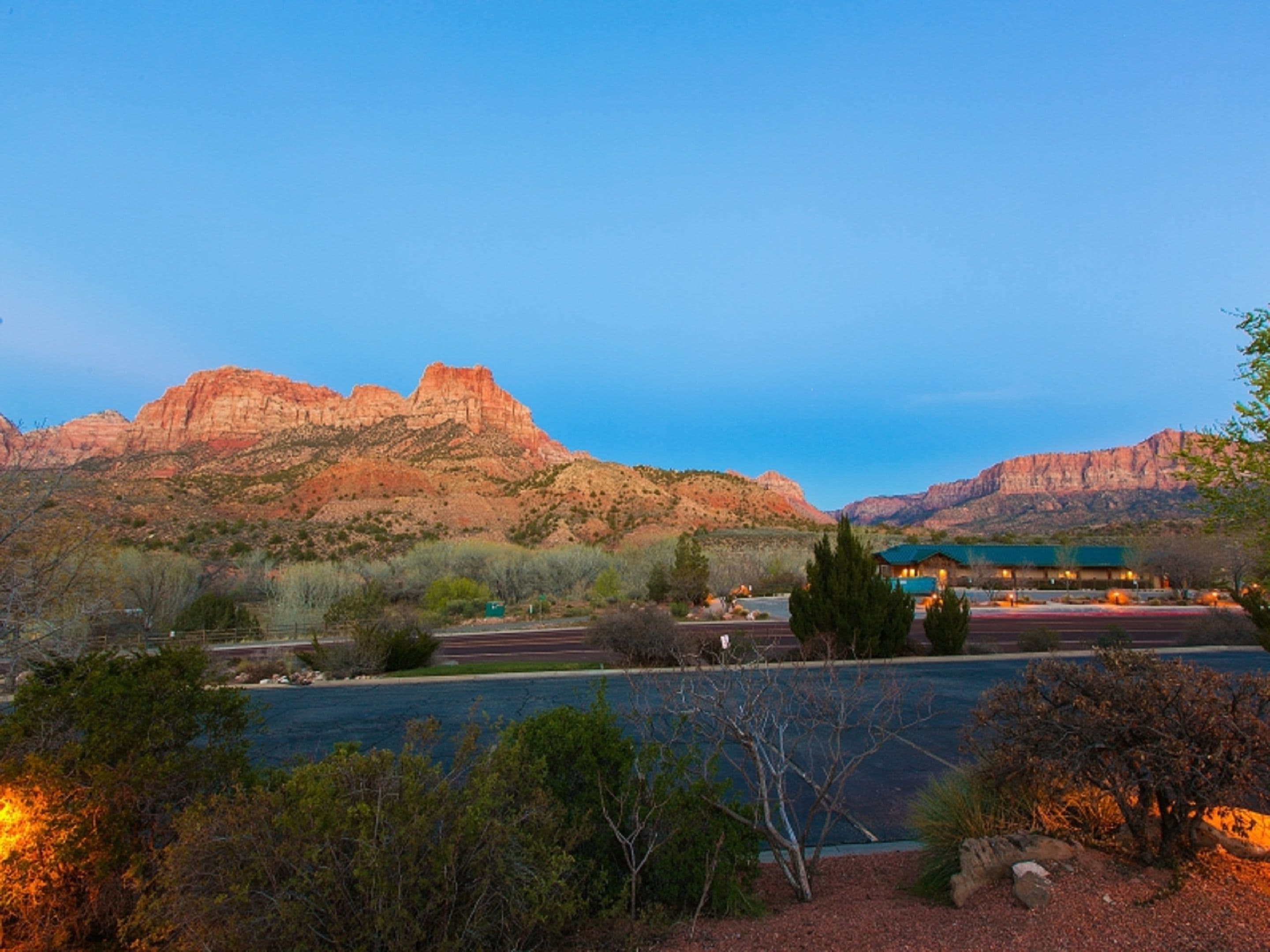 A hotel with a view of red rock formations and a body of water.