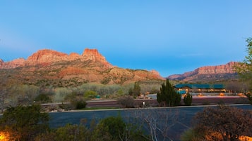 A hotel with a view of red rock formations and a body of water.