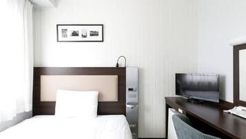A hotel room with a bed, a desk with a television, a small cabinet, and a framed picture on the wall.