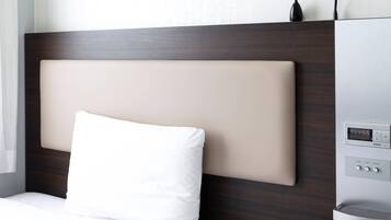 Una habitación de hotel con una cama moderna, un reloj digital y un panel de control para la configuración de la estancia.