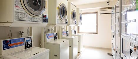A laundry facility with multiple washing machines and dryers, including a CO/N washer and a 45kg dryer.