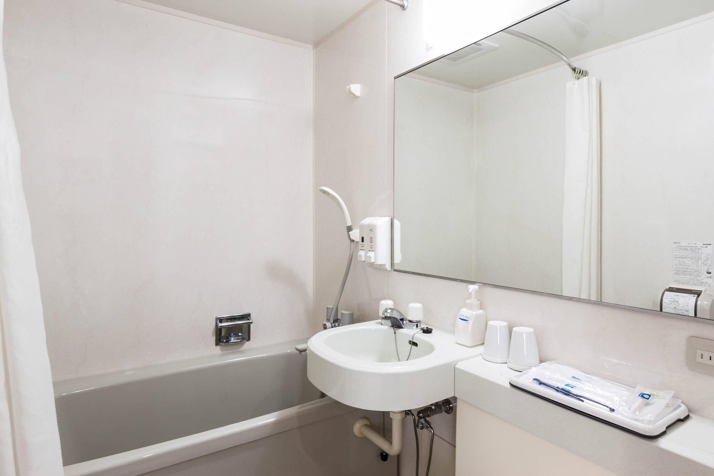 A modern bathroom with a bathtub, a sink, and a mirror.