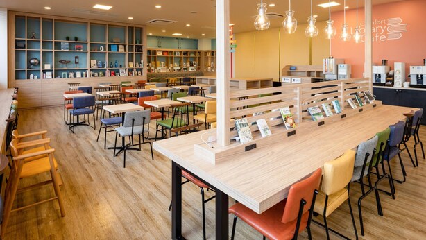 A library cafe with wooden tables and chairs, bookshelves, and a coffee bar. - Comfort Hotel Hamamatsu (Hamamatsu)