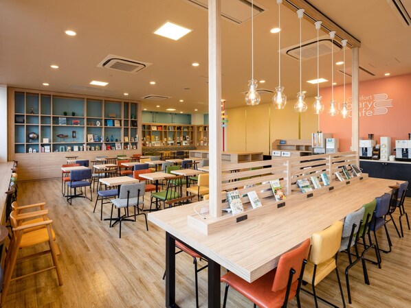 A library cafe with wooden tables and chairs, bookshelves, and a coffee bar.