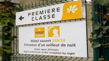 Señal de hotel que indica servicio las 24 horas con un vigilante nocturno en la recepción.