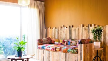 A room with a wooden bench, a small table, and a potted plant.