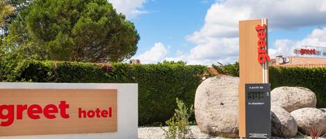 A hotel sign with 'greet hotel' and a vertical sign with 'greet' and 'la chambre' visible.