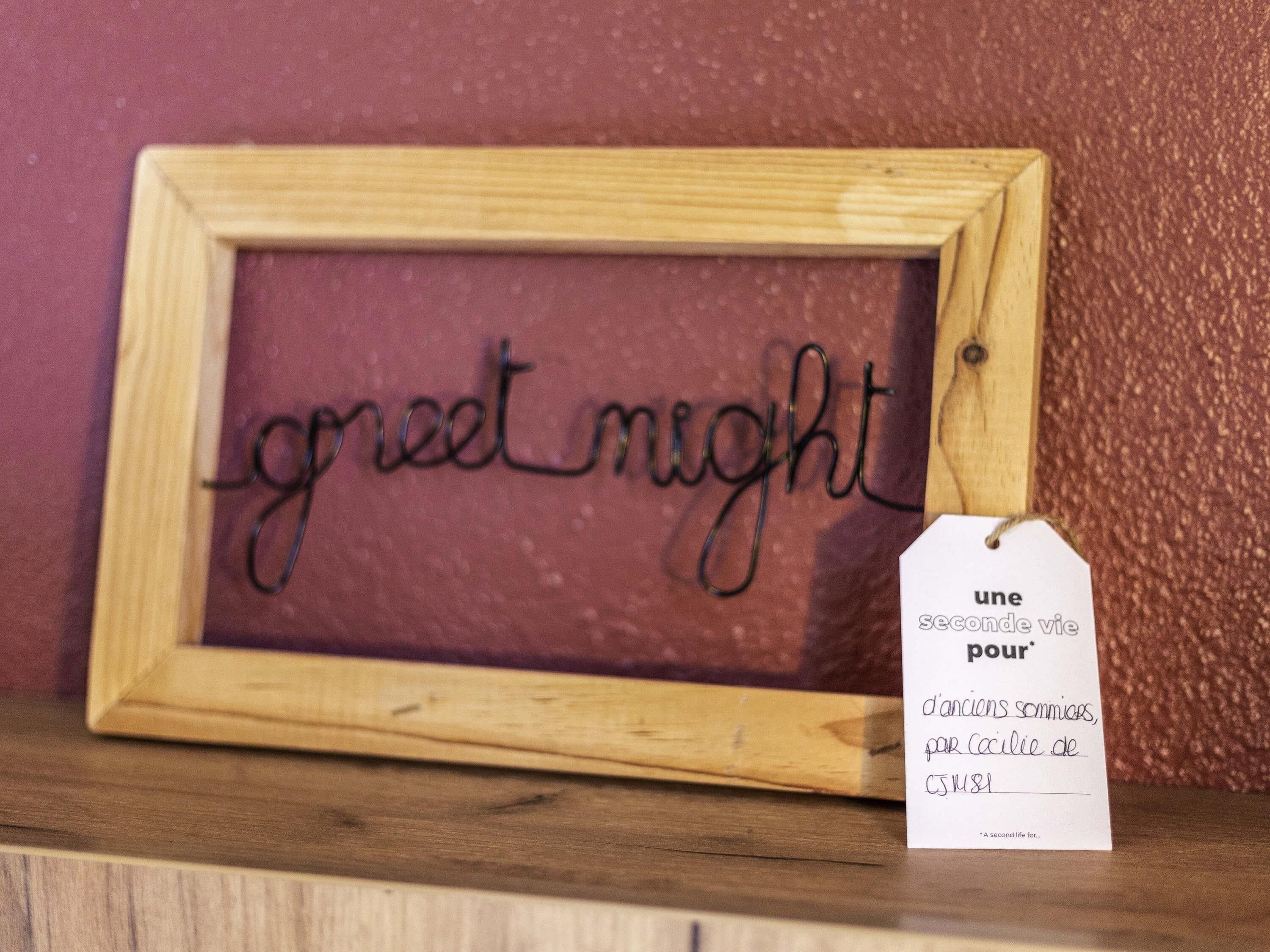 Un letrero de madera con la frase 'good night' y una etiqueta con texto en francés.