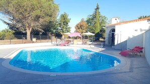 A swimming pool with lounge chairs and umbrellas, surrounded by trees and a white building. - Greet Hotel Castres Saïx (Saix)