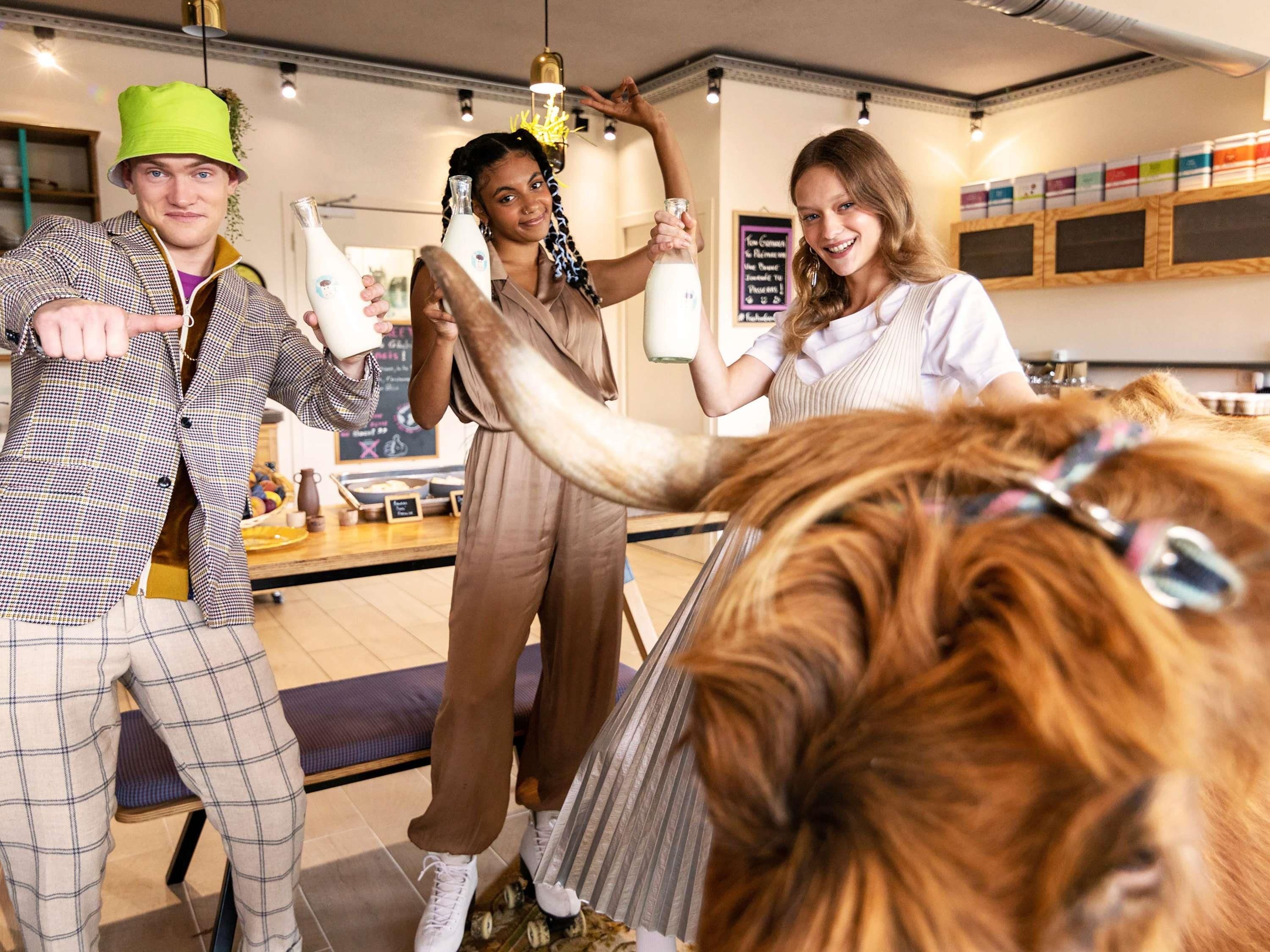 A group of people in a modern interior with a counter and various items on display.
