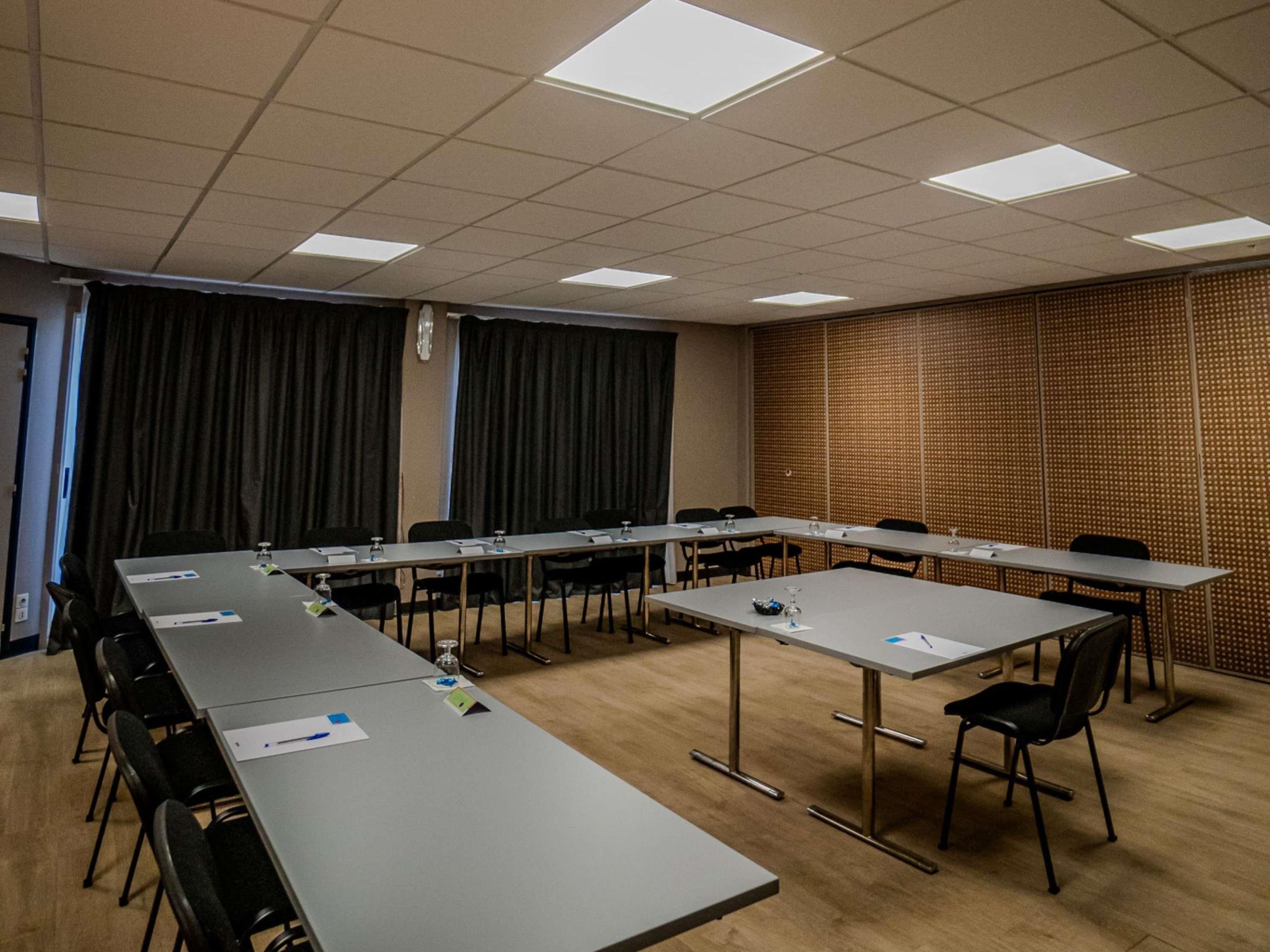 A conference room with a long table, chairs, and a patterned wall.