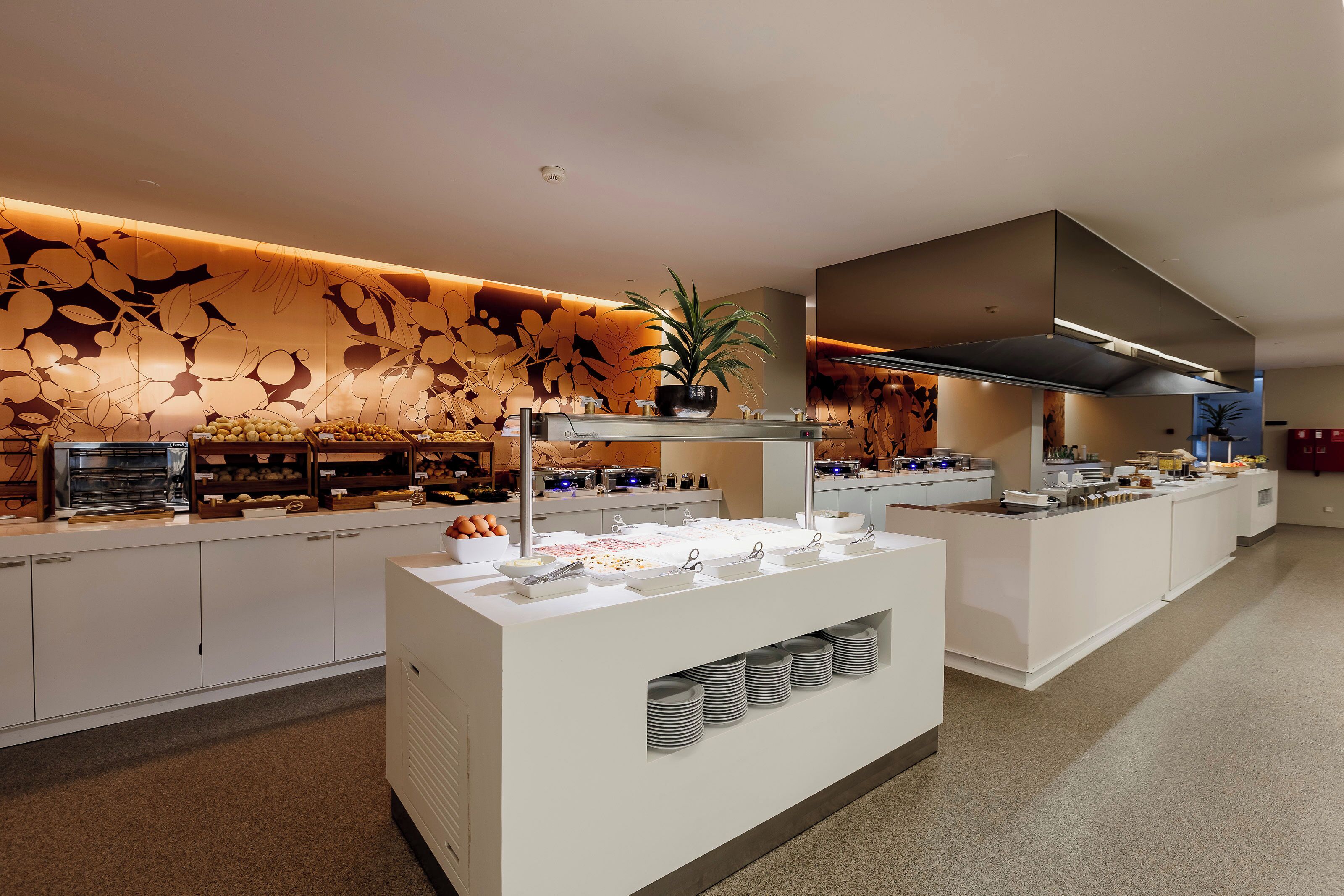 A modern buffet setup with various food items and a decorative wall.
