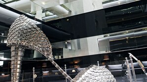 Un interior moderno con una escultura metálica única que recuerda a una estructura con forma de concha.