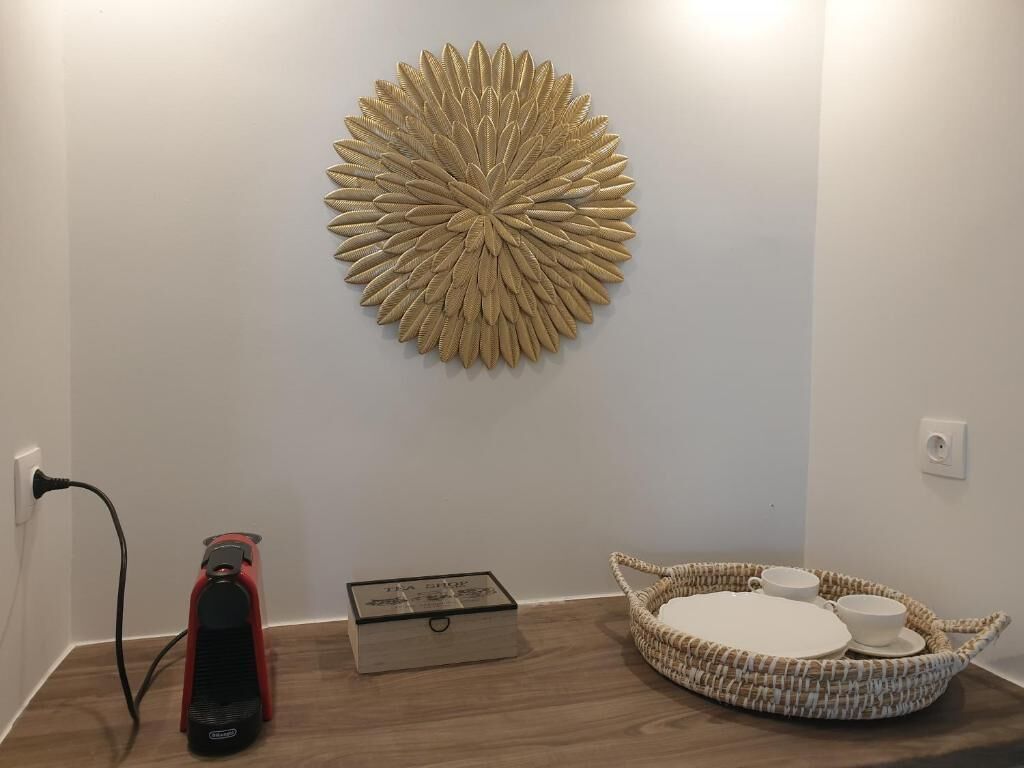Ein Zimmer mit einem Wanddekor, einem Staubsauger, einer Kiste und einem gewebten Korb mit Tassen.