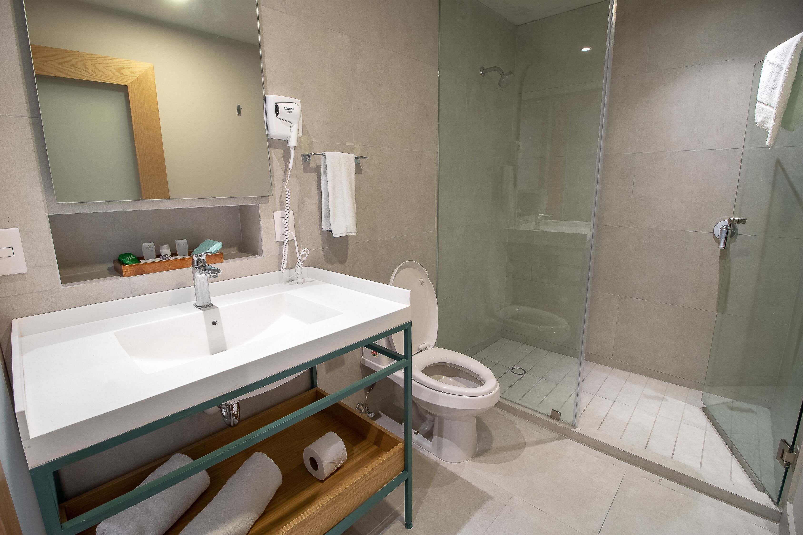 A modern bathroom with a white sink, toilet, and glass-enclosed shower.