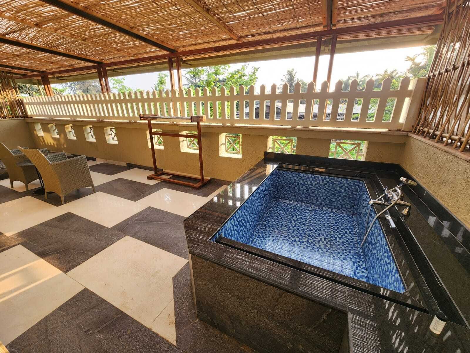 A pool area with a checkered floor, a hot tub, and a bamboo ceiling.
