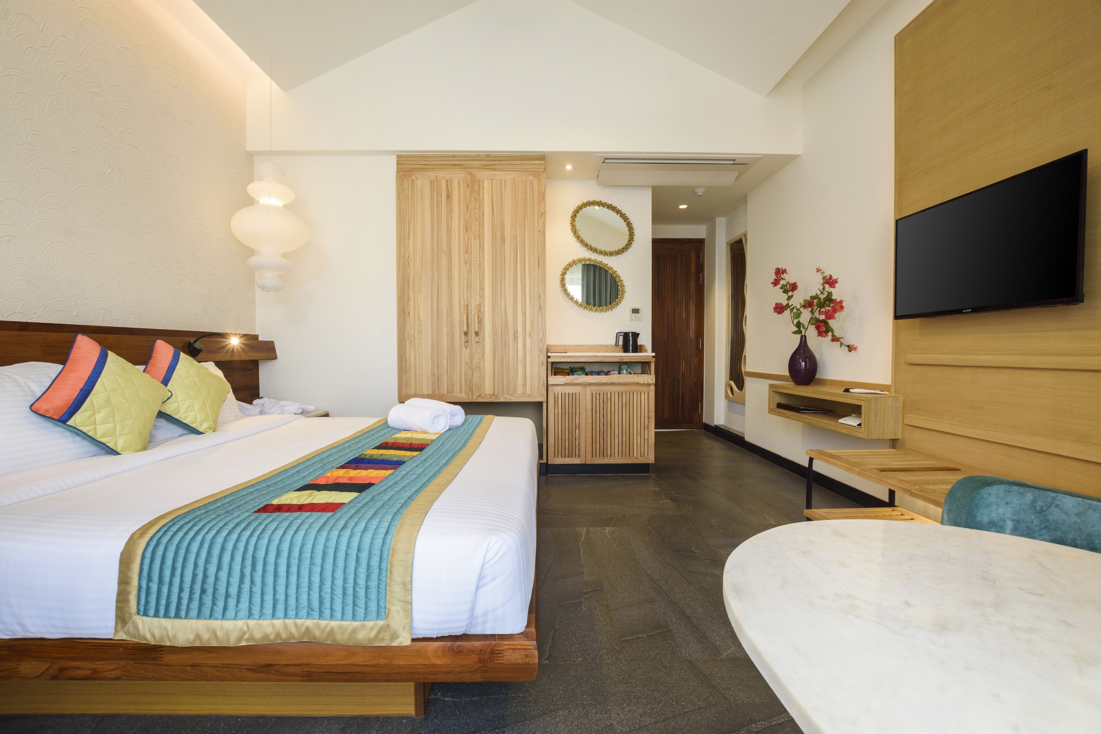Una camera d'albergo con un letto grande, una scrivania, una televisione e un bagno.