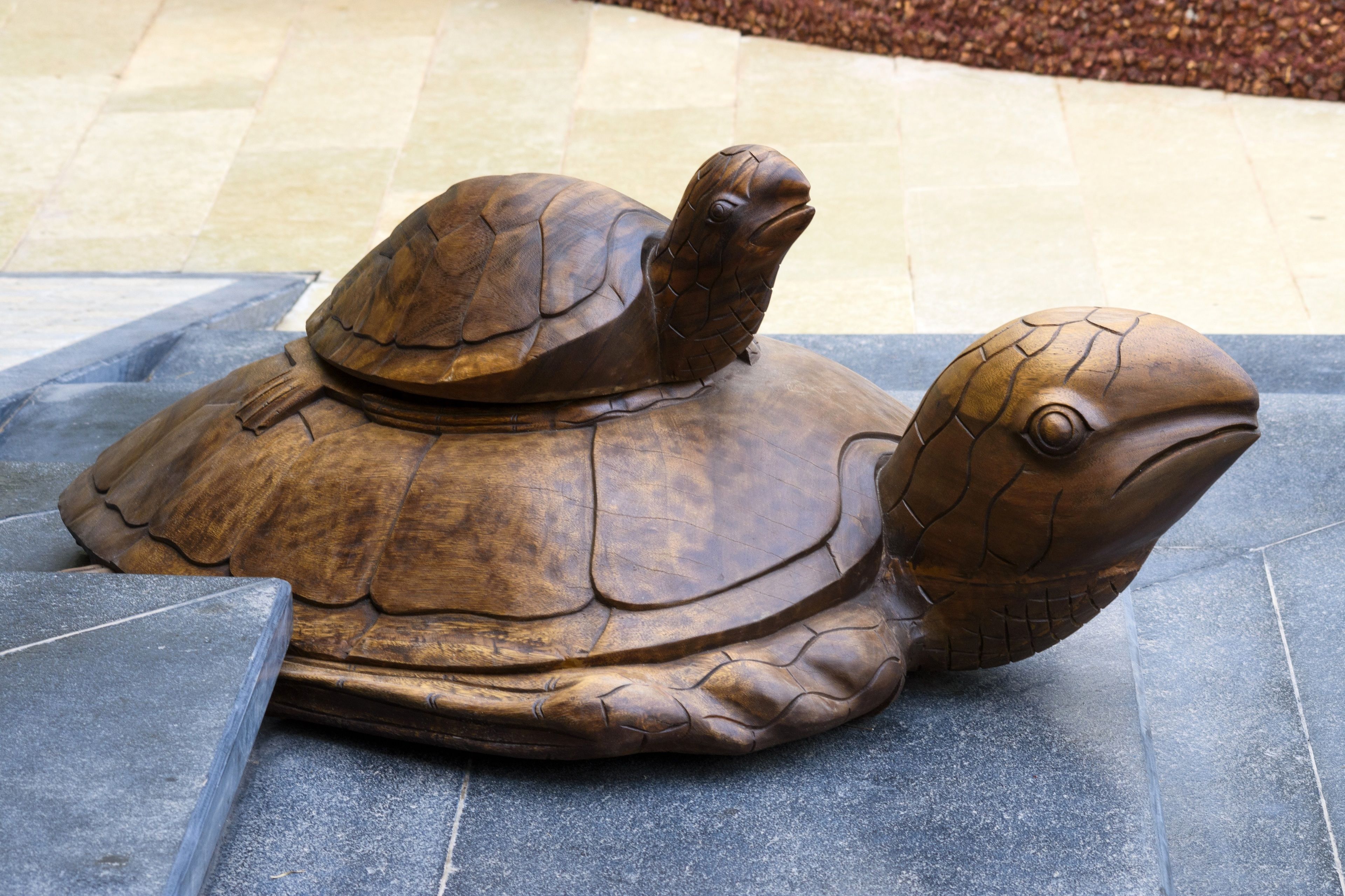 A bronze turtle sculpture on a stone platform.