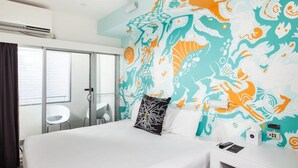 A hotel room with a bed, a white nightstand, a wall with a colorful mural, a window with curtains, and a door. - Majestic Minima Hotel (North Adelaide)