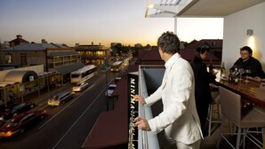 A balcony with a view of a street at dusk. - Majestic Minima Hotel (North Adelaide)