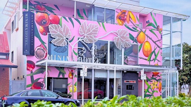 A building with a vibrant fruit mural, a glass facade, and a sign for 'MINIMA HOTEL'. - Majestic Minima Hotel (North Adelaide)