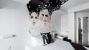 A modern hotel room with a bed, a nightstand, and a wall-mounted lamp. - Majestic Minima Hotel (North Adelaide)