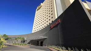 A modern hotel with a prominent 'Marriott' sign, a curved facade, and a covered entrance area.